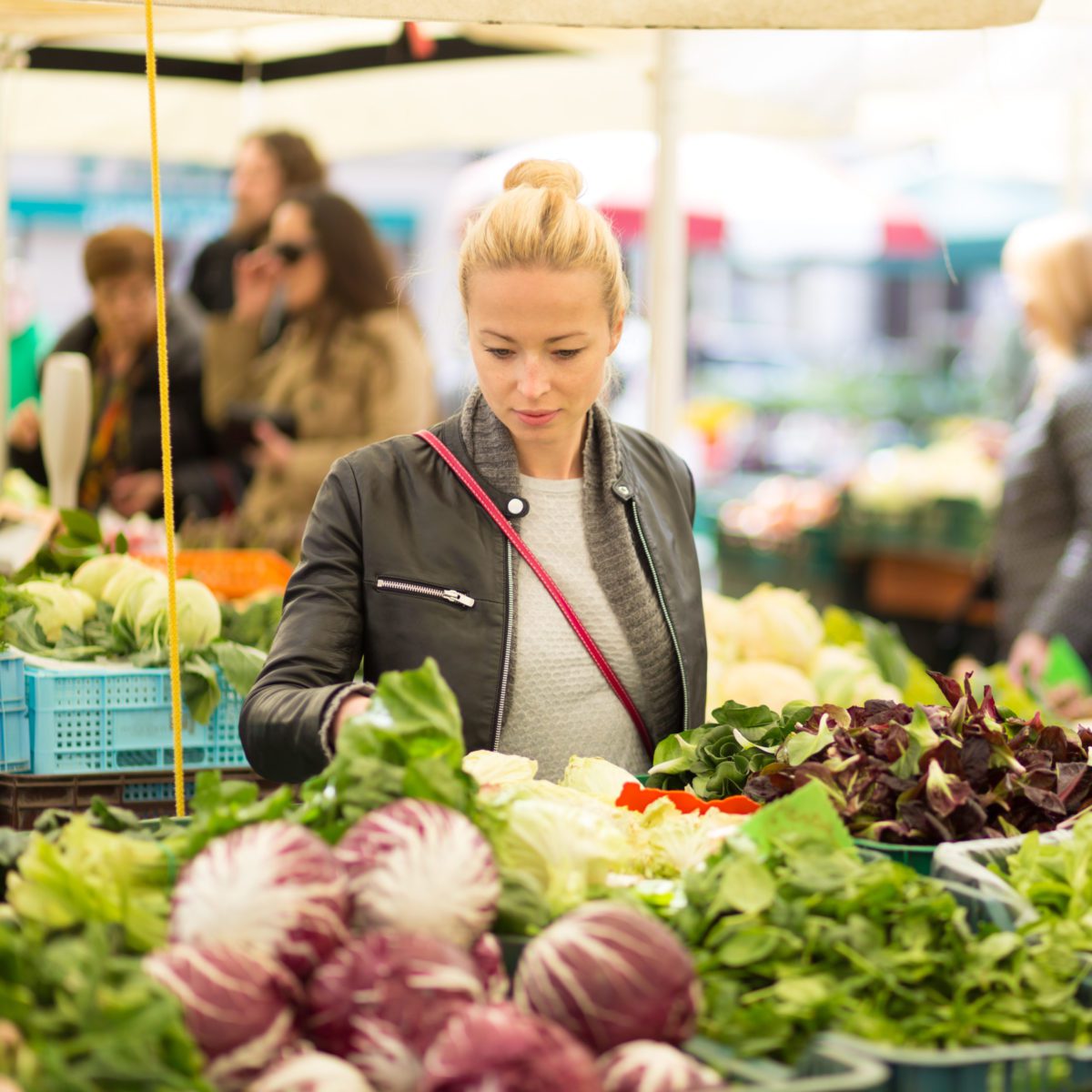 Woman buying vegetable at local food market.